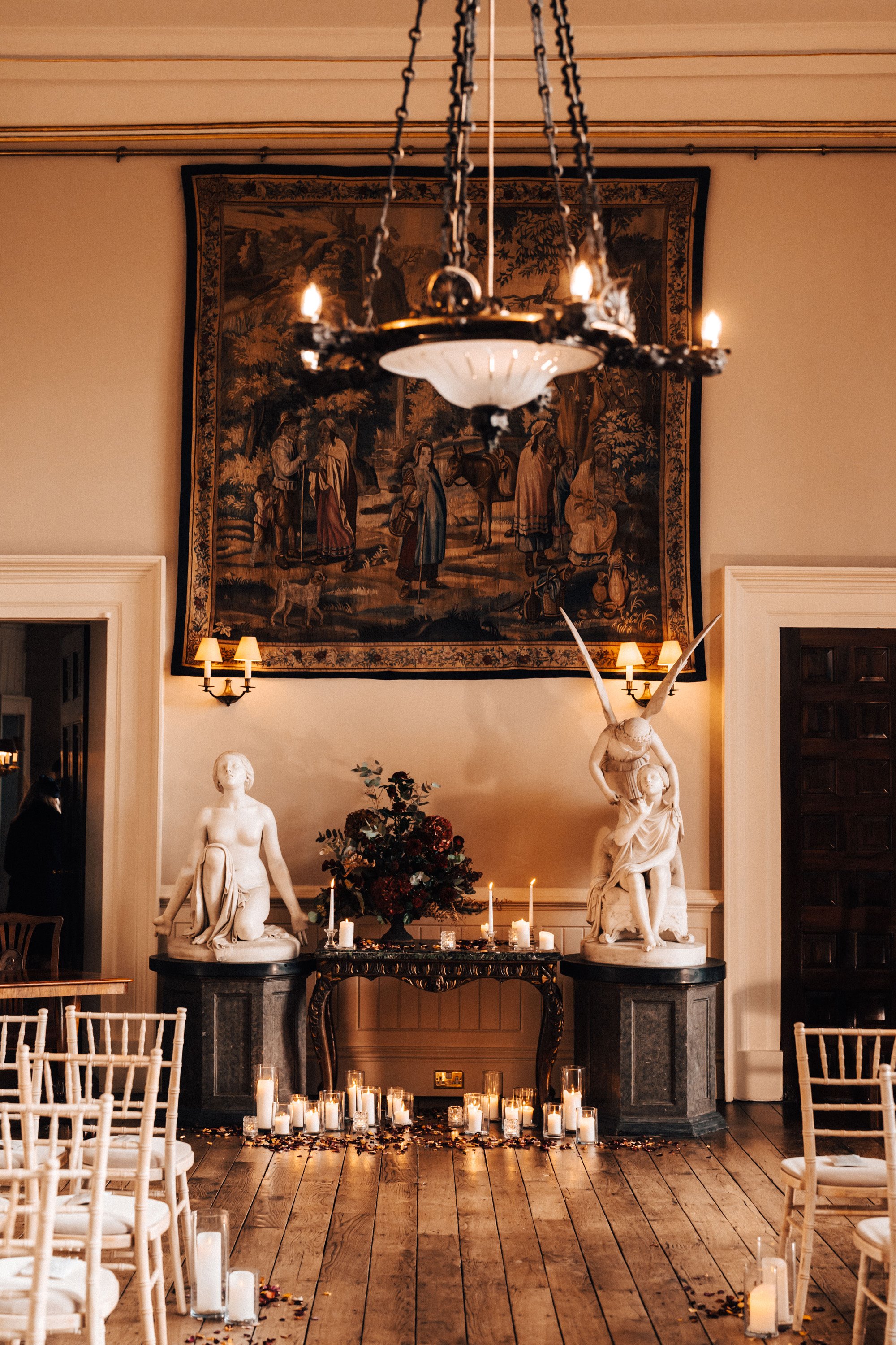 Winter wedding ceremony in a mansion house hall decorated with candles and christmas flowers