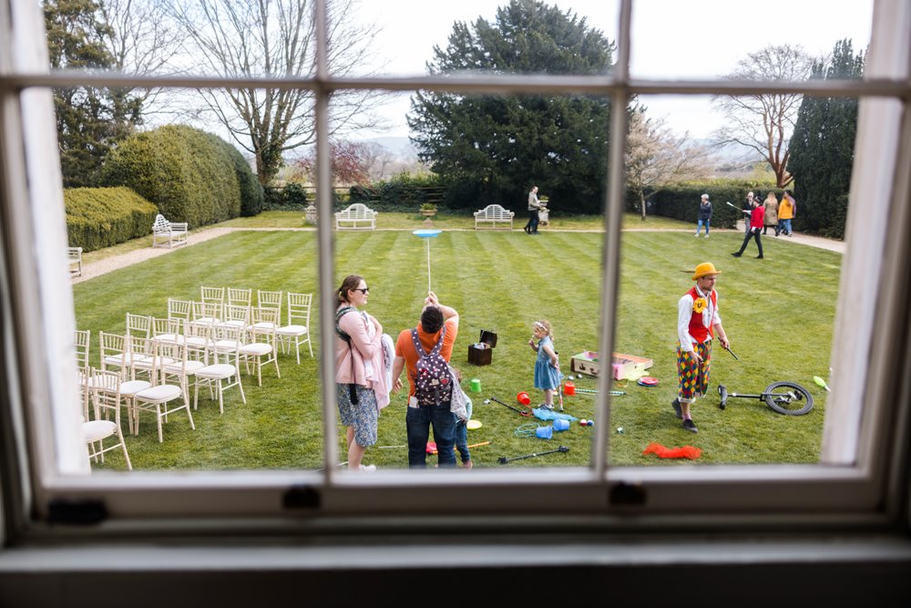 clown with circus skills games for children on the lawn at elmore court for an eccentric english garden party