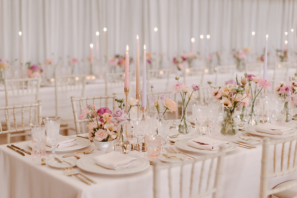 Whimsical table setting at a romantic Elmore Court wedding, with flowers and candles on a beautifully dressed table 