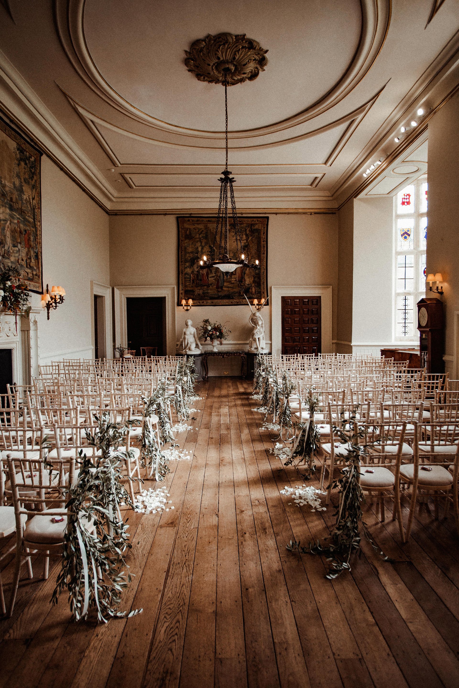 Autumnal wedding ceremony hall decorated with greenery at stately home elmore court