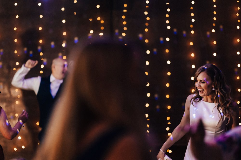 bride and guests dancing at Party wedding venue with cool lighting and funktion one sound system at their autumnal wedding in the cotswolds