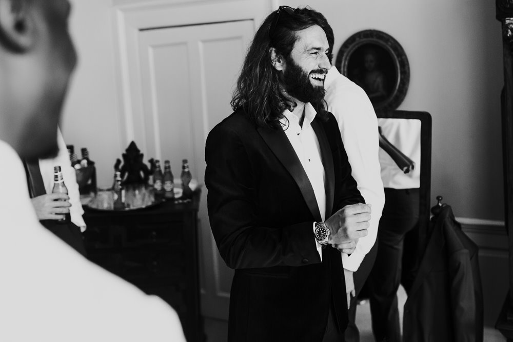 sexy groom with long hair getting ready on his wedding morning in stately home