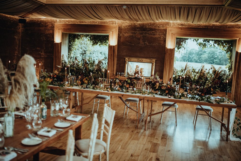 Rustic dark wedding florals in wedding reception venue cotswolds