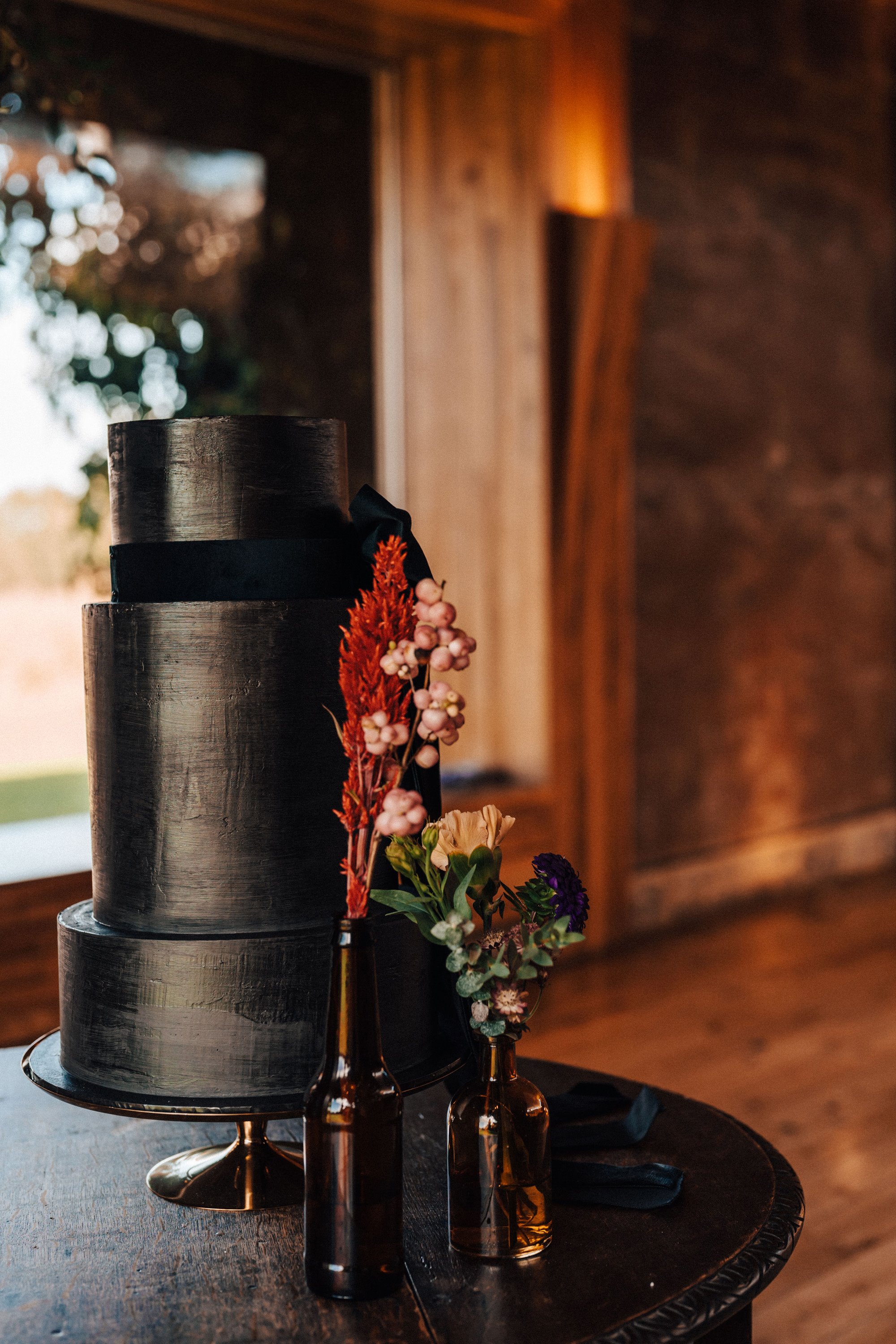 Black wedding cake for a black wedding theme close to halloween in october at a sustainable wedding venue in the english countryside