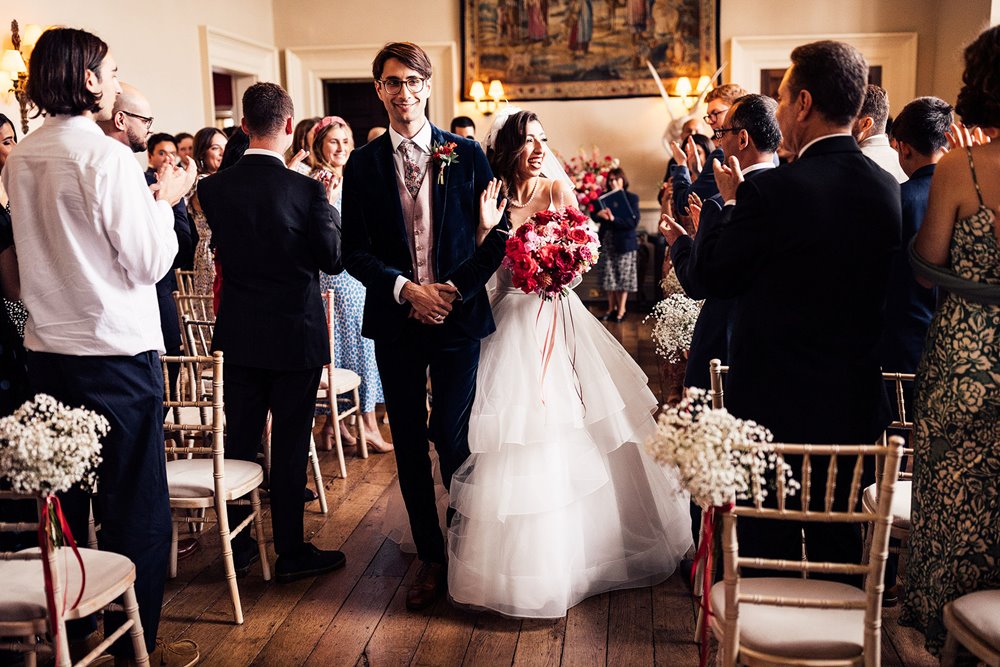 Just married bride and groom walk down the aisle at wedding ceremony in elmore court stately home