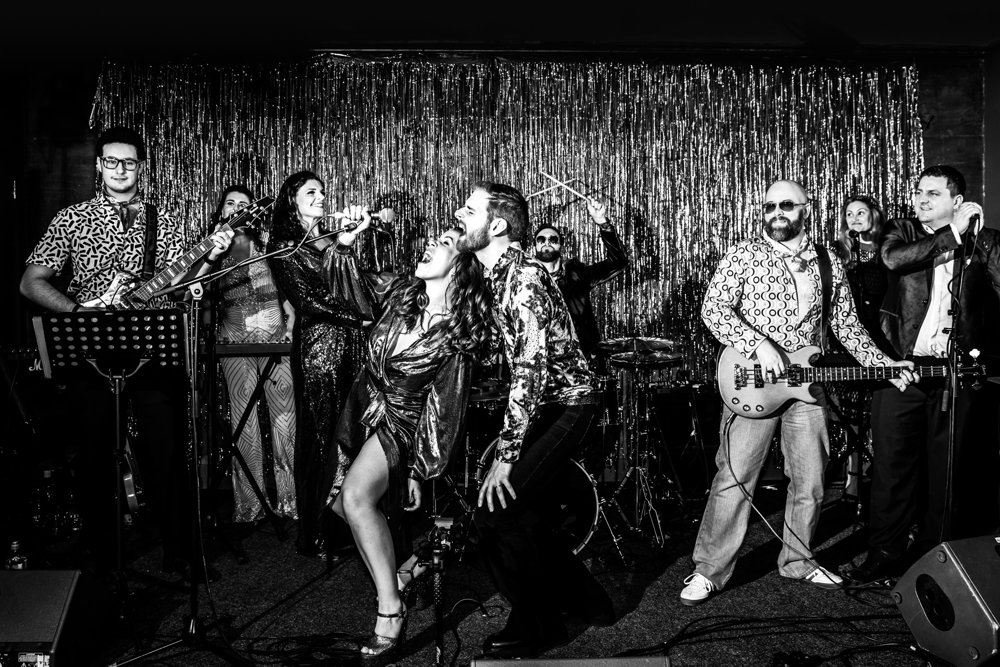 Wedding band with bride and groom singing alone on stage at their huge weekend long party wedding