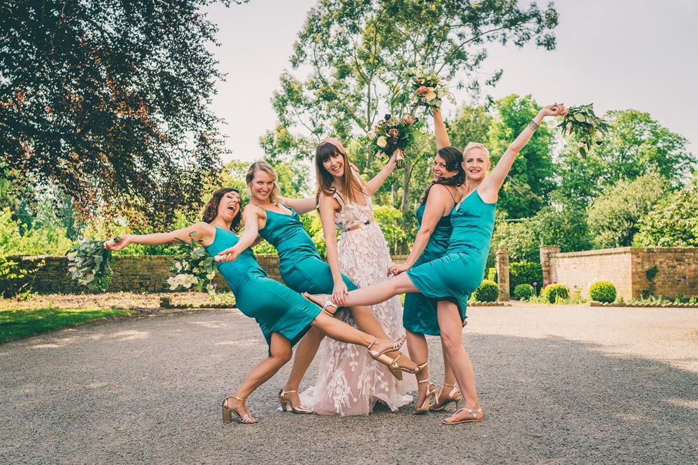 Bright green bridesmaids do fun poses with bride 2021 wedding inspiration