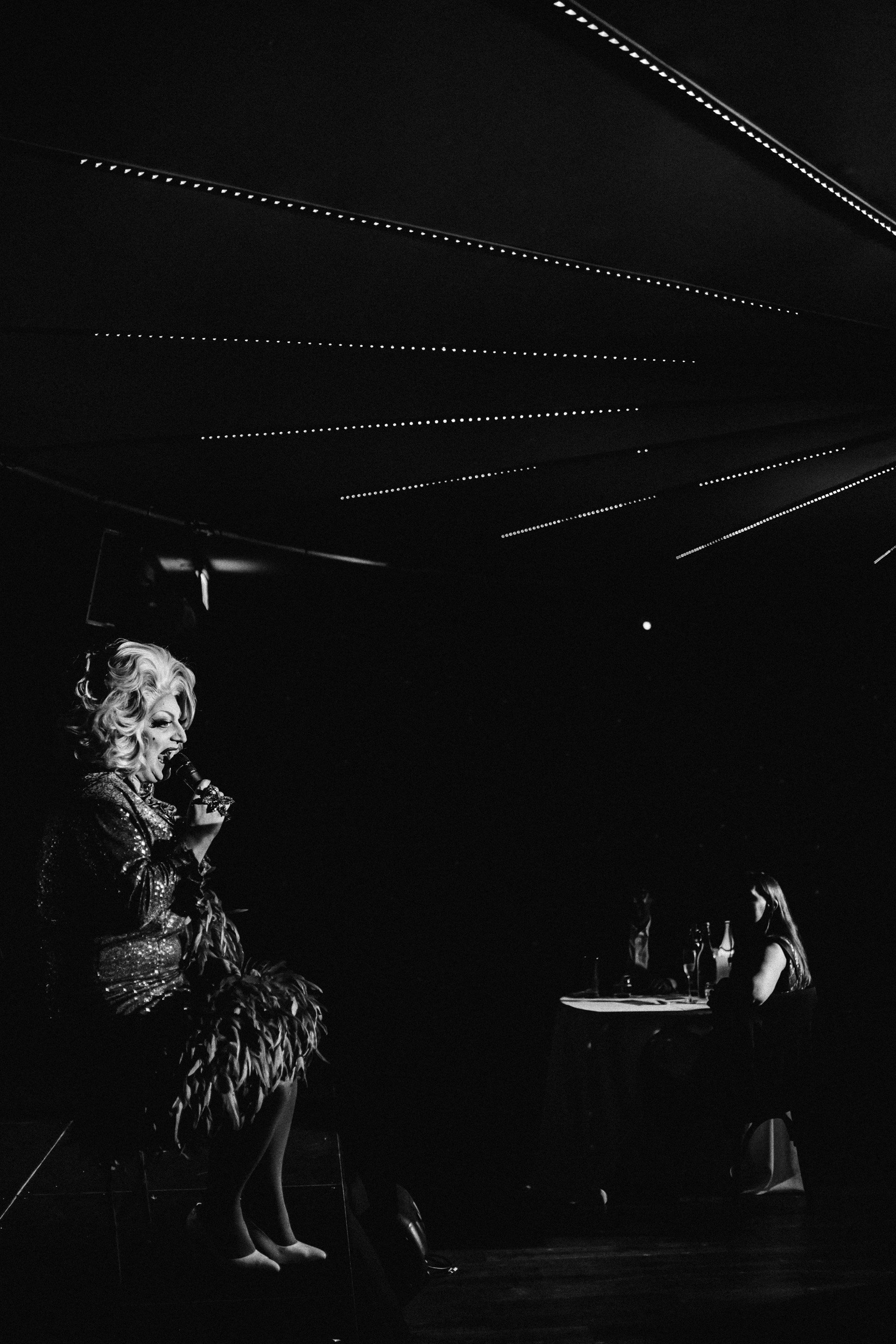 Cabaret drag queen in black and white on stage at elmore court