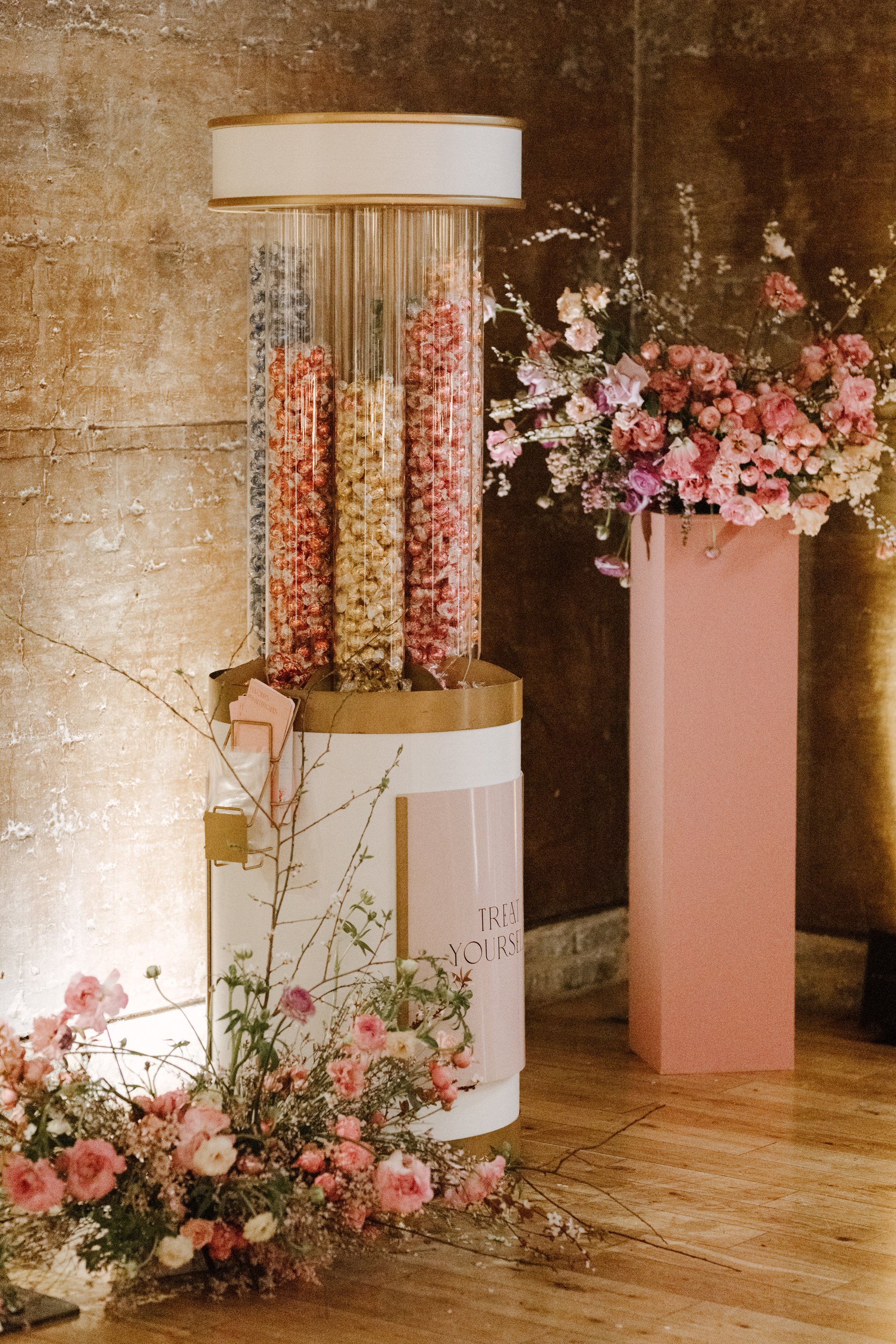 a tower of pink and gold wedding chocolates and bouquets of flowers in the Gillyflower