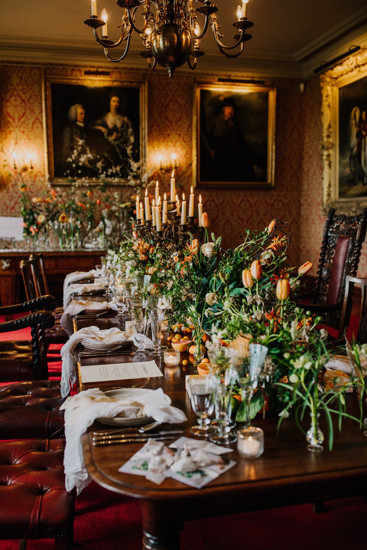 Old dining room in stately home decorated with modern luscious spring flowers, greenery and candelabras for wedding fair open day in march
