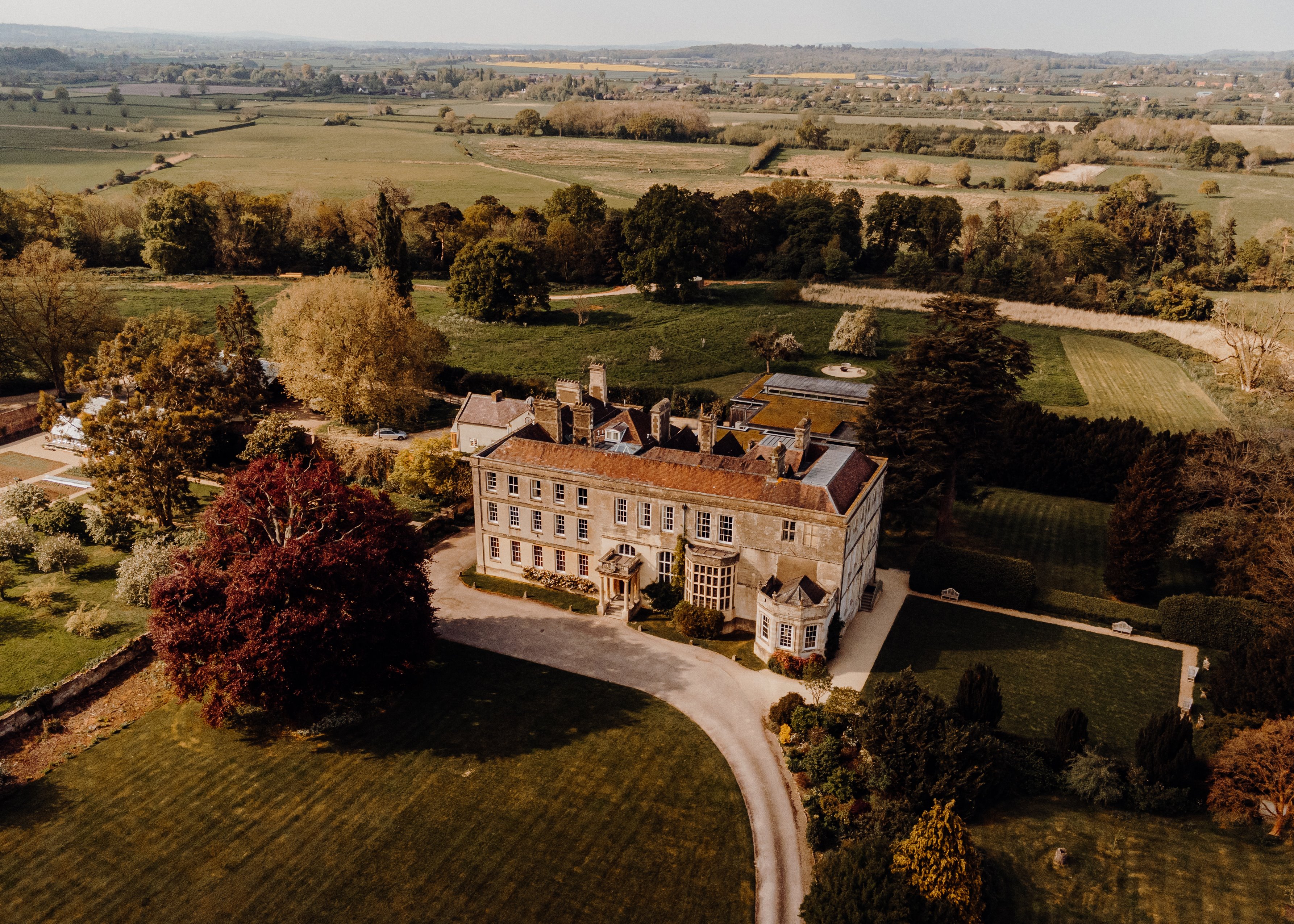 Cotswolds countryside wedding venue estate from above with rolling hills, lush fields and walled garden all around with exlcusive use and weekend weddings available