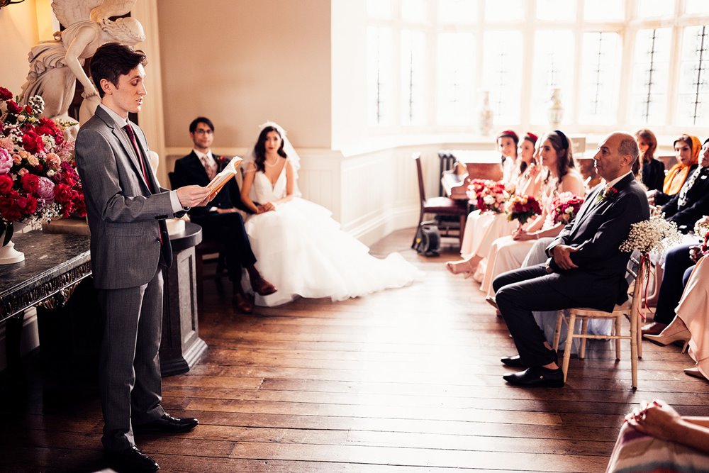 poetry reading by guest at wedding ceremony in the hall of stately home elmore court in the cotswolds