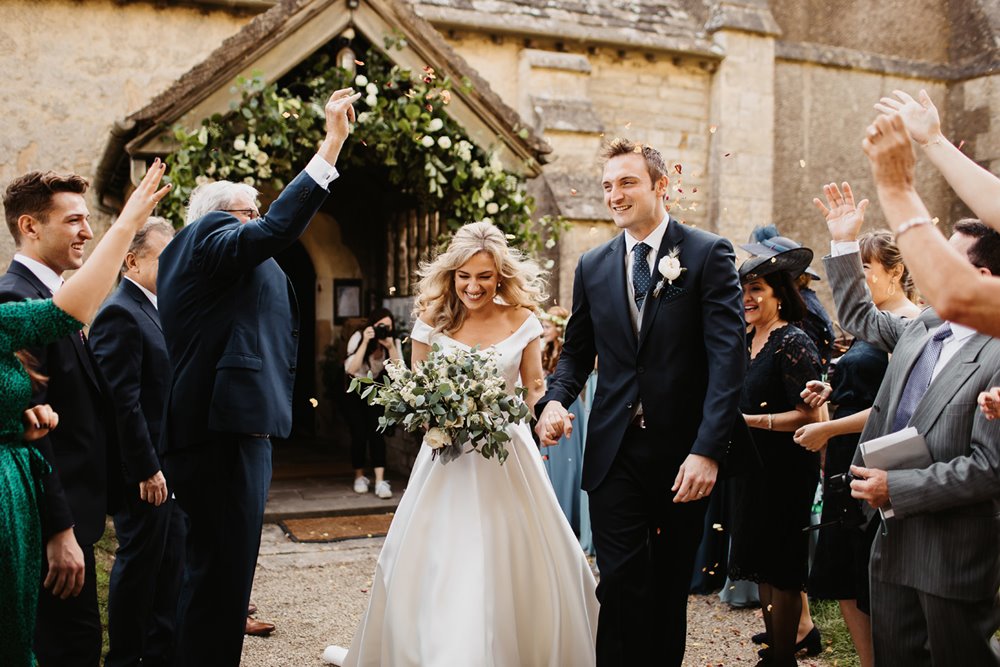 Confetti thrown on bride and groom leaving church as a married couple in elmore UK