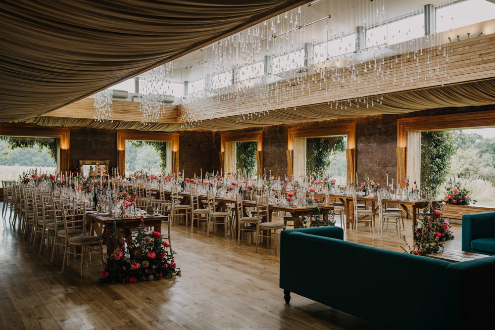 Pretty luxe boho wedding reception venue with lots of light and twinkling light shower decorated with pink flowers and candles for a wedding