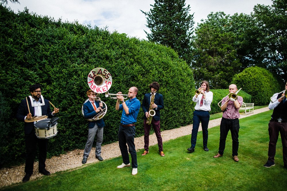 Brass band playing on the lawn at a festival garden wedding at elmore court