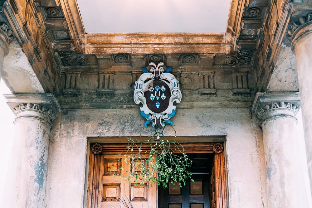 Family crest of stately home decorated with mistletoe for a christmas wedding in the cotswolds