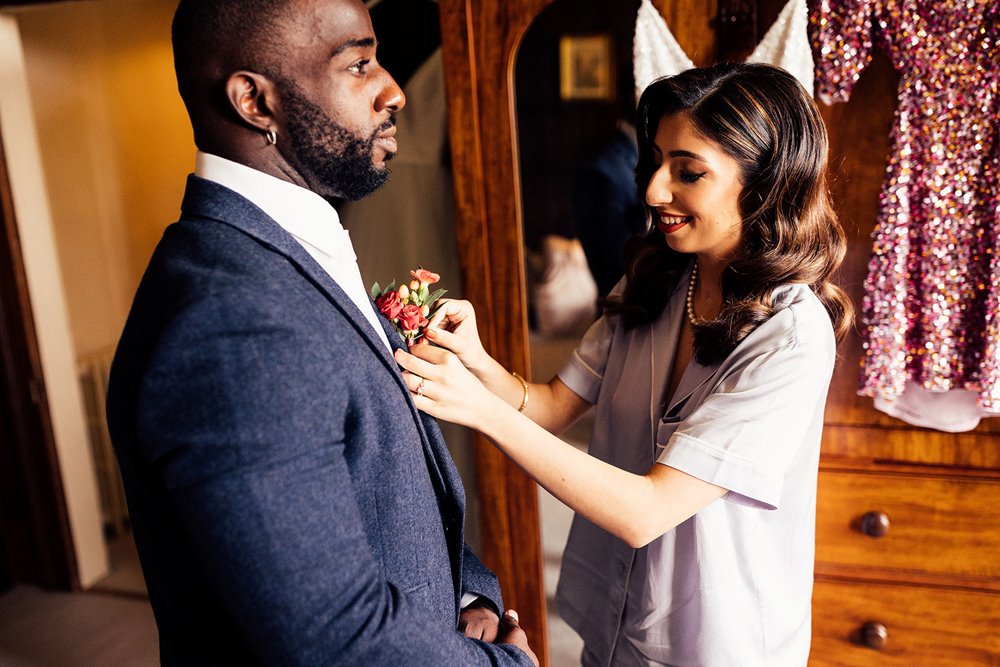 Beautiful moment as Bride does her bridesmans buttonhole for him