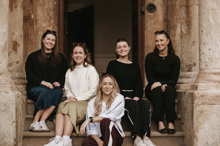 Team E pictured on the steps of Elmore Court