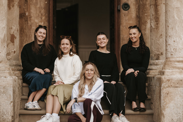 Team E pictured on the steps of Elmore Court