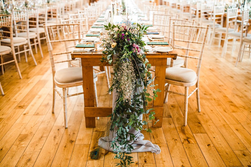 Trailing floral tablescape on long banquet tables at huge wedding reception