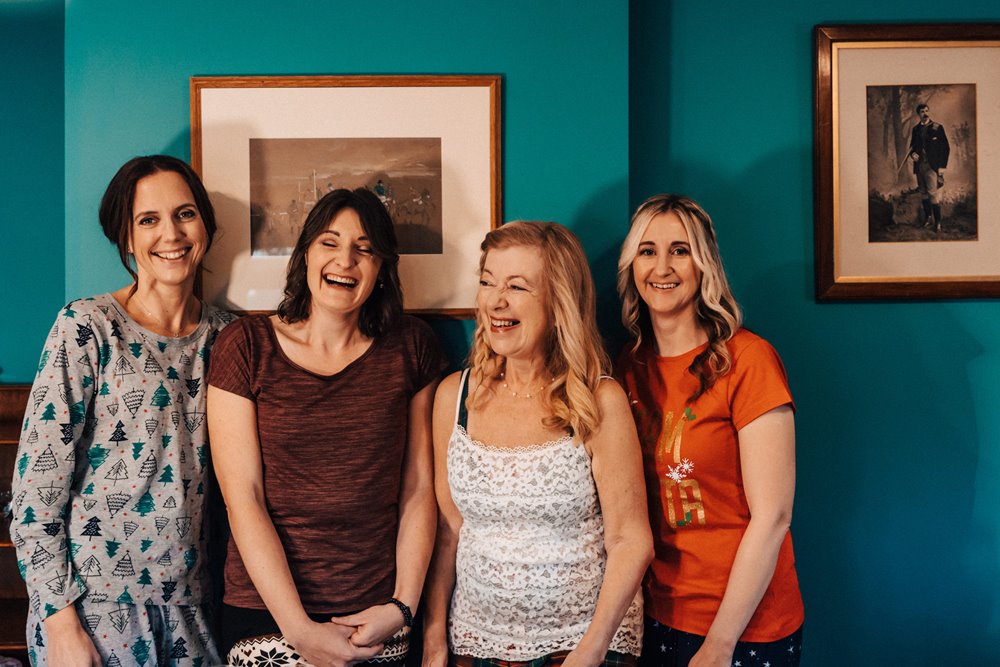 bridal party having fun on wedding morning in the coach house at elmore court