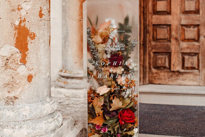 Unusual Romantic autumnal wedding sign of 3D perspex filled with flowers on the steps of stately home