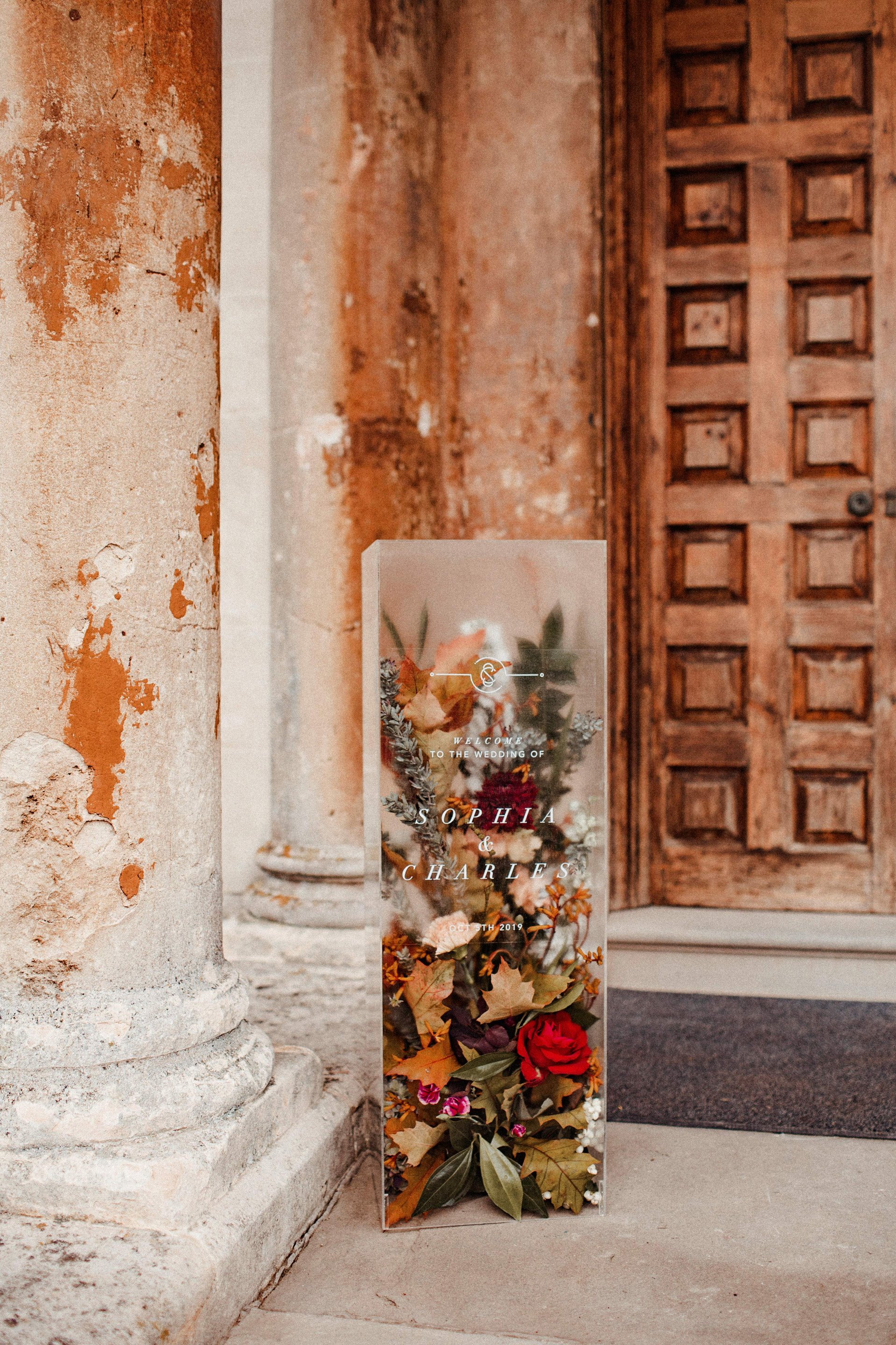 Unusual Romantic autumnal wedding sign of 3D perspex filled with flowers on the steps of stately home