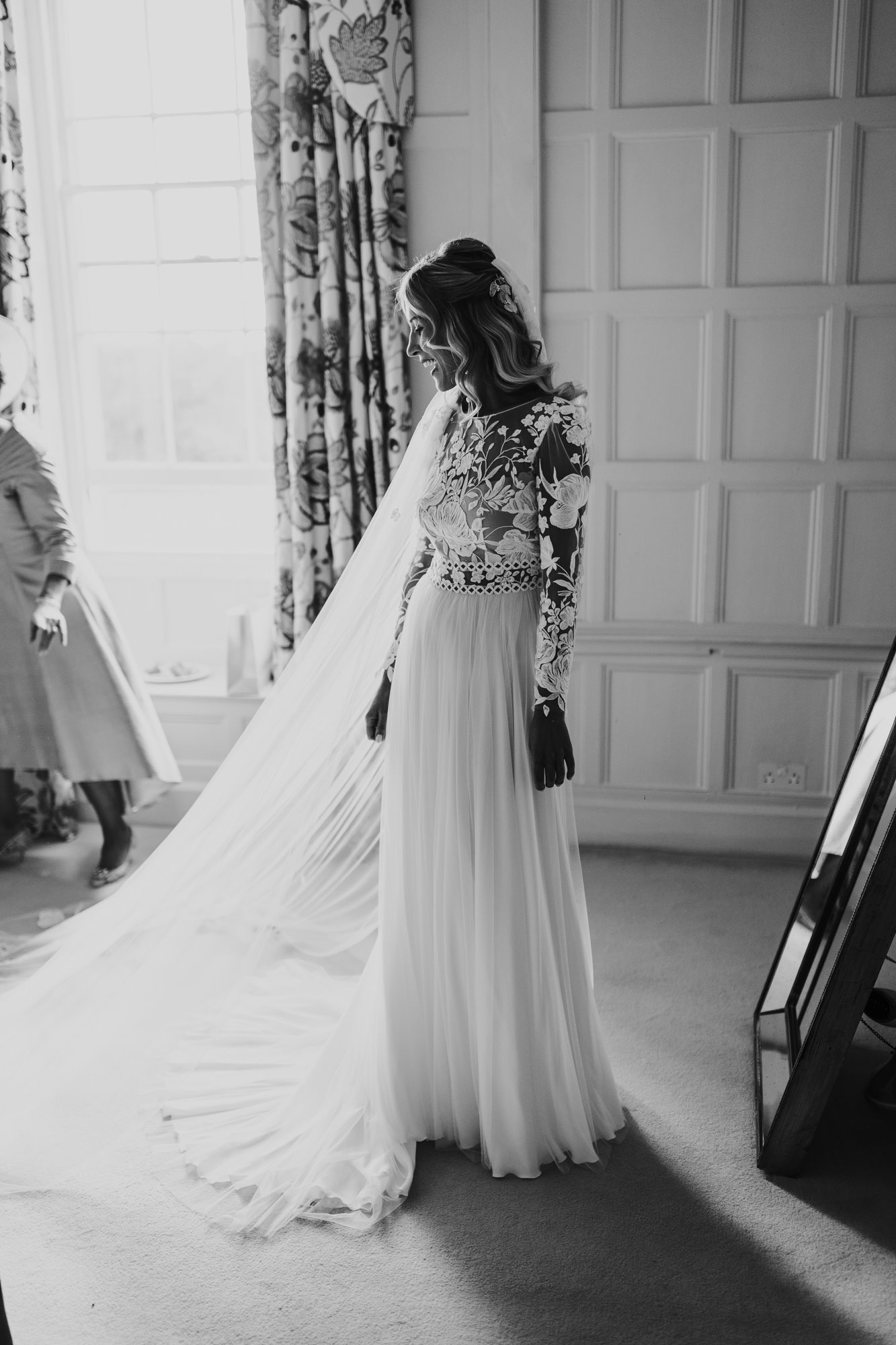 modern boho bride puts in long veil in stately home bedroom