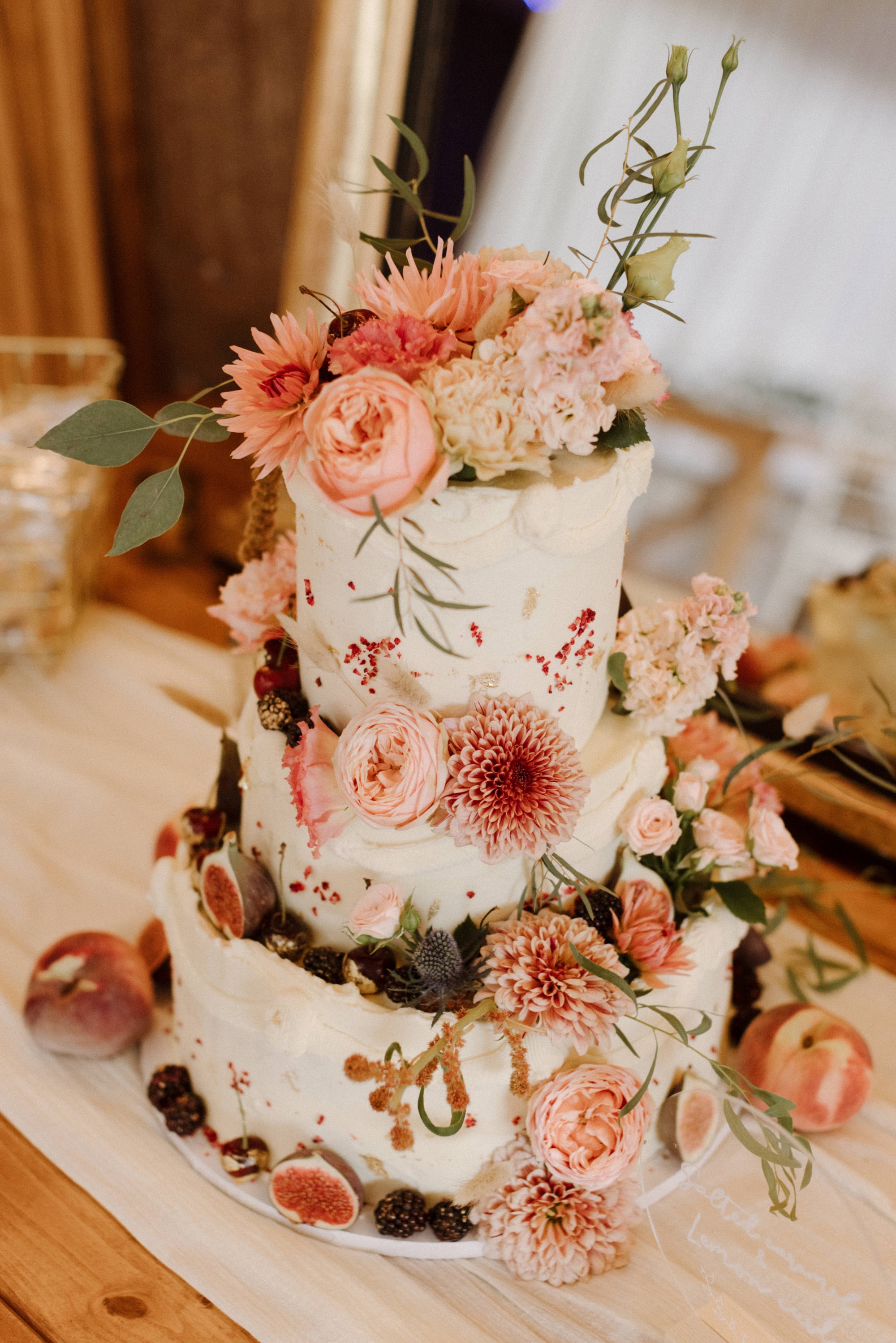 pink flowers decorated on a tiered wedding cake