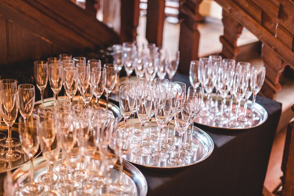 Champagne glasses on silver trays waiting to be filled at a gay wedding