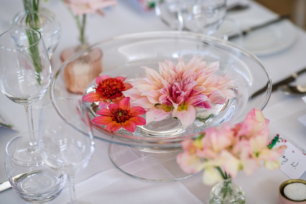 Pink wedding flowers floating in water for gay wedding reception