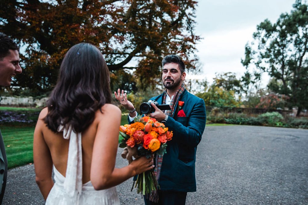 Micro wedding bride with orange bouquet poses for photographs