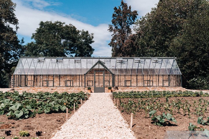 The new greenhouse at Elmore Court sitting proudly in the 700 year old walled garden surrounded by organic seedlings popping up fresh for sustainable wedding menus as soon as covid allows