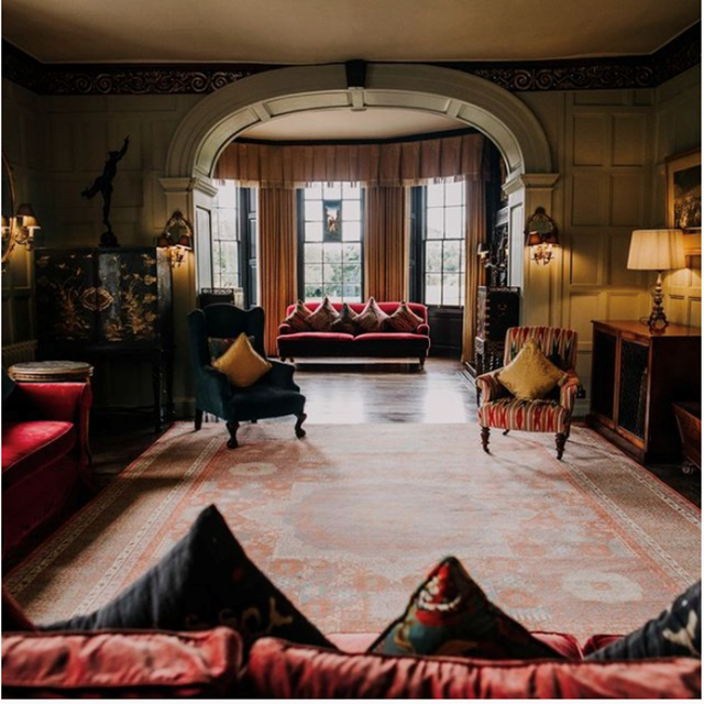 Historic house drawing room in stately home elmore court with red velvet sofas and beautiful curved walls