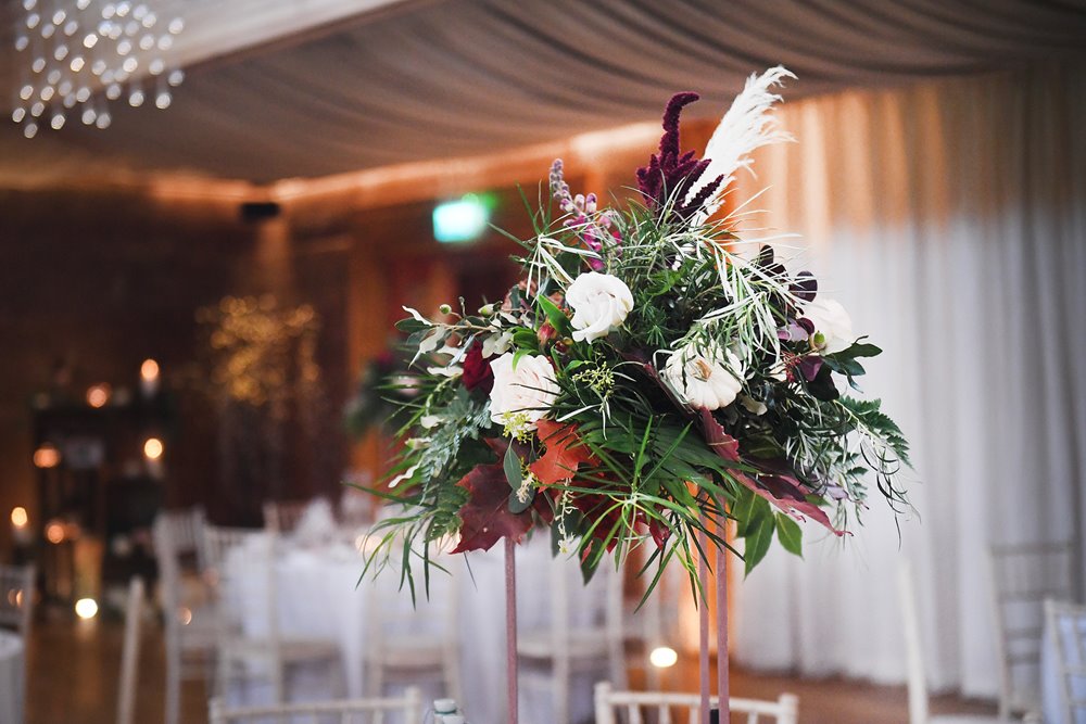 Autumnal wedding floral centerpieces with white pumpkins decorating eco reception venue in gloucestershire