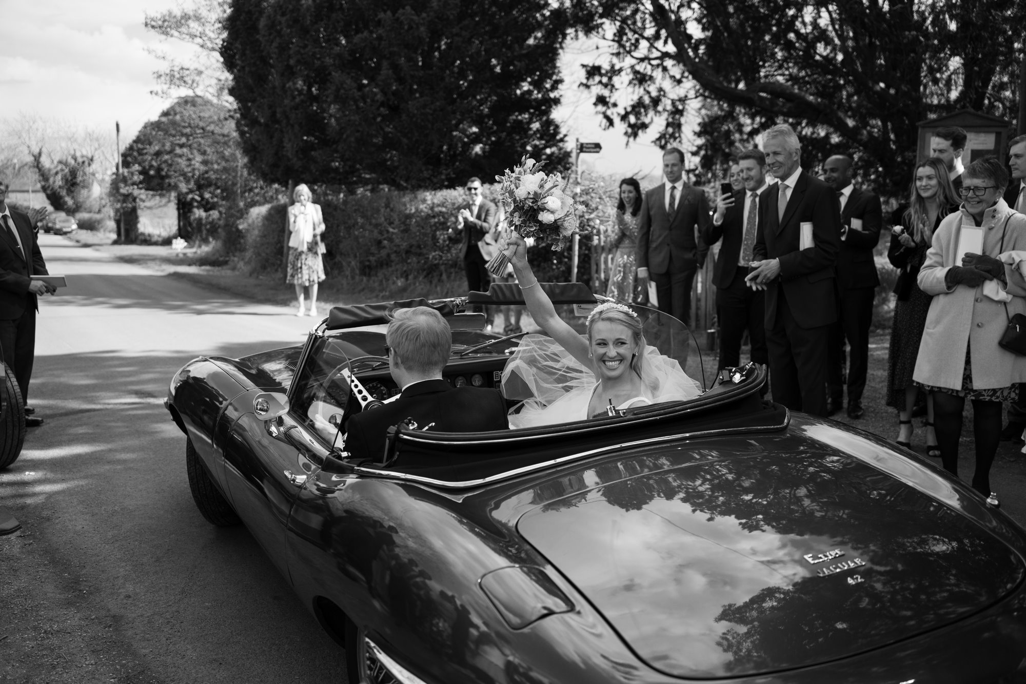 beautiful bride being driven away in a classic car after getting married at Elmore Court