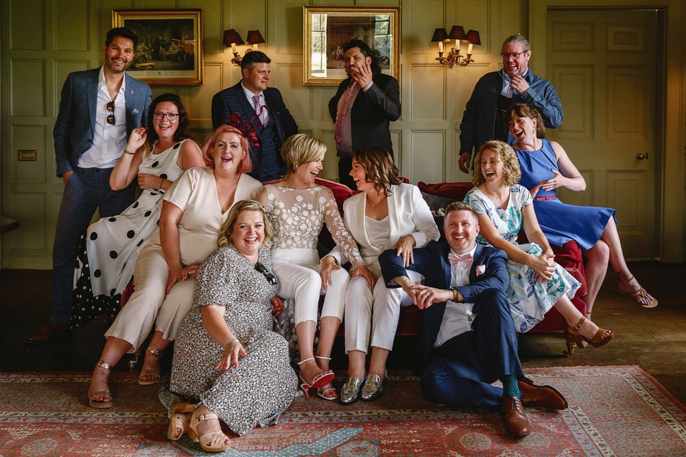 Relaxed group shots at lesbian wedding celebration in stately home