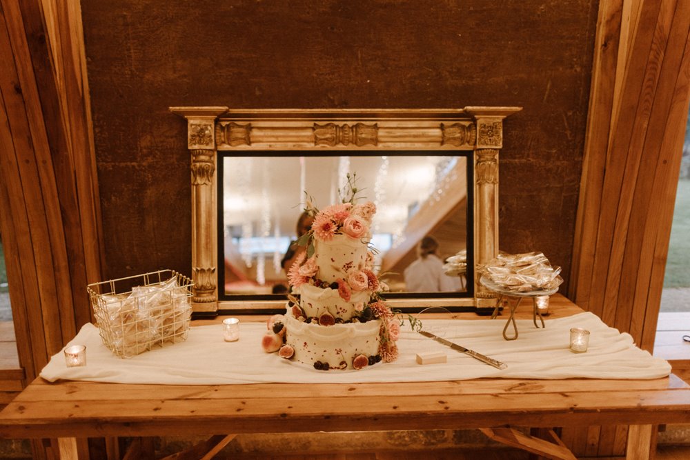 Beautiful boho wedding cake decorated with real pink flowers for a boho luxe wedding in the cotswolds