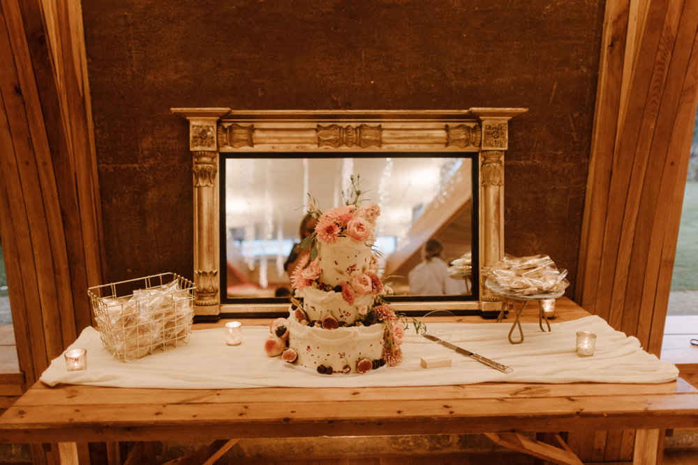 Beautiful boho wedding cake decorated with real pink flowers for a boho luxe wedding in the cotswolds