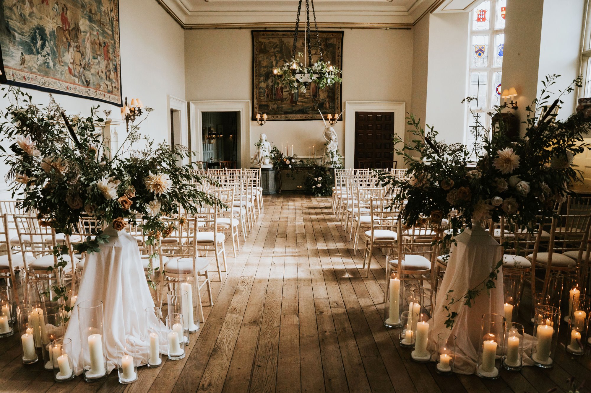 candles and flowers decorate the great hall of a wedding ceremony at Elmore Court