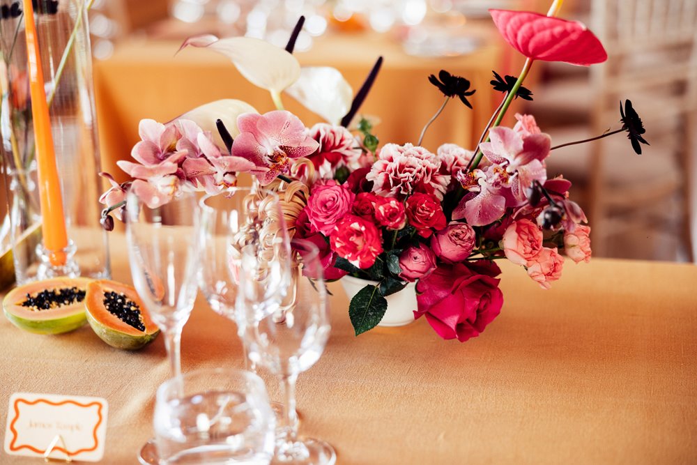 Colourful wedding flowers and fruit on wedding reception tables at elmore court