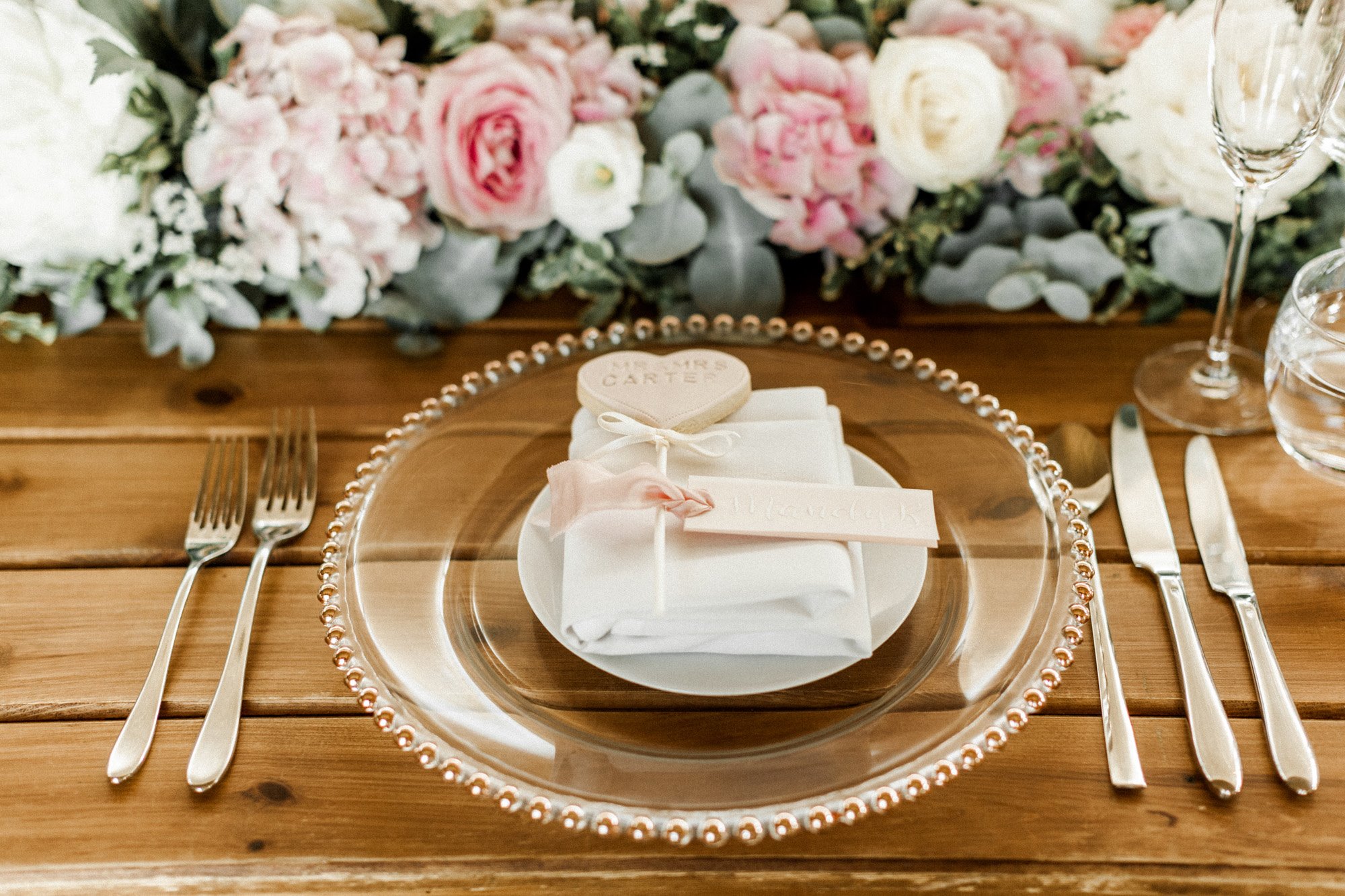 roses on a wedding table with clear plate and love lollipop