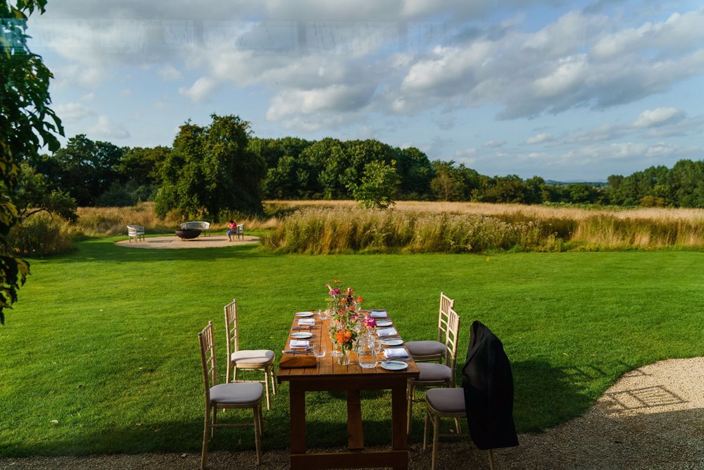 Outdoor table set up in the gillyflower meadow for a relaxed wedding rehearsal in the cotswolds