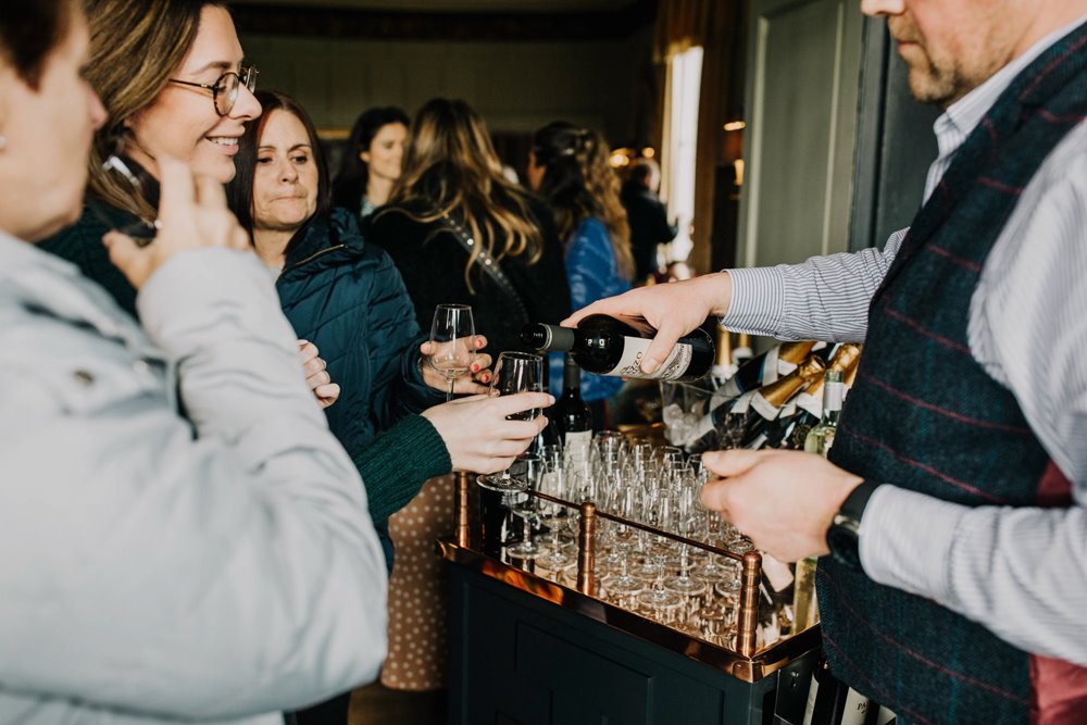 sommelier giving wine advice and tasters at wedding fair in the cotswolds