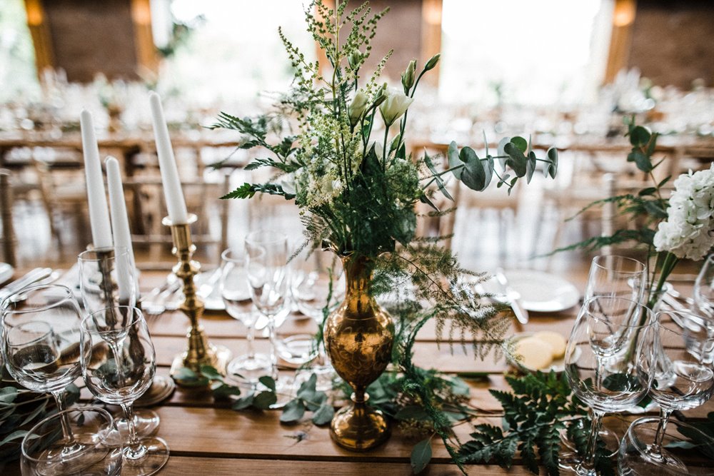 Natural wedding decor with greenery and white candles for a rustic wedding at Elmore Court