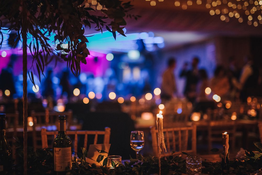 Purple atmospheric dance floor in candlelit room for a gay wedding party at elmore court