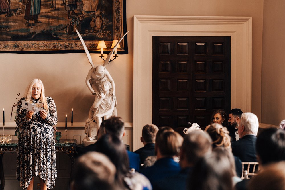 mother of bride reading at an autumn wedding ceremony in historic house in england