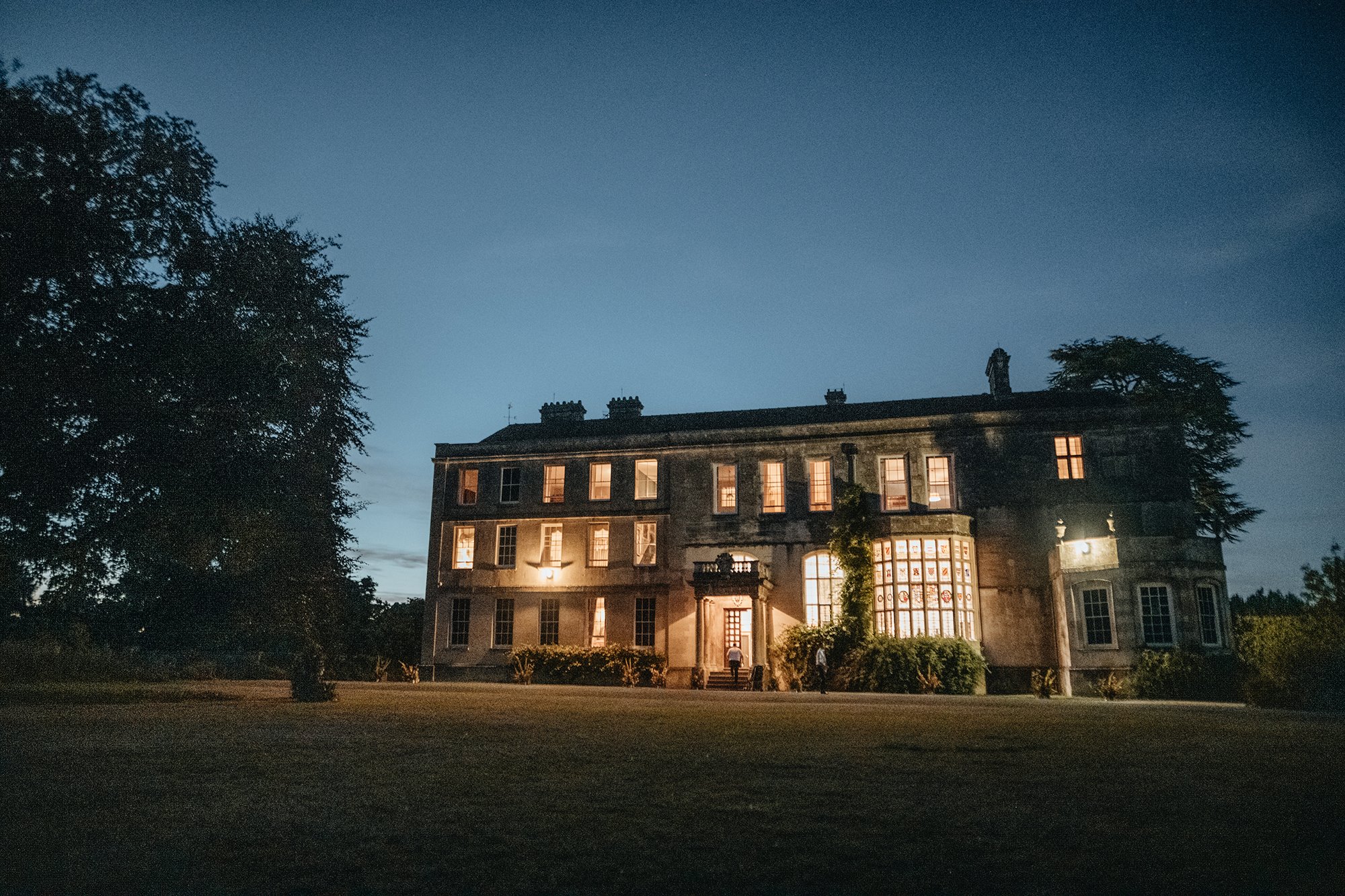 beautiful stately home wedding venue lit up at night for a luxury wedding in the cotswolds countryside