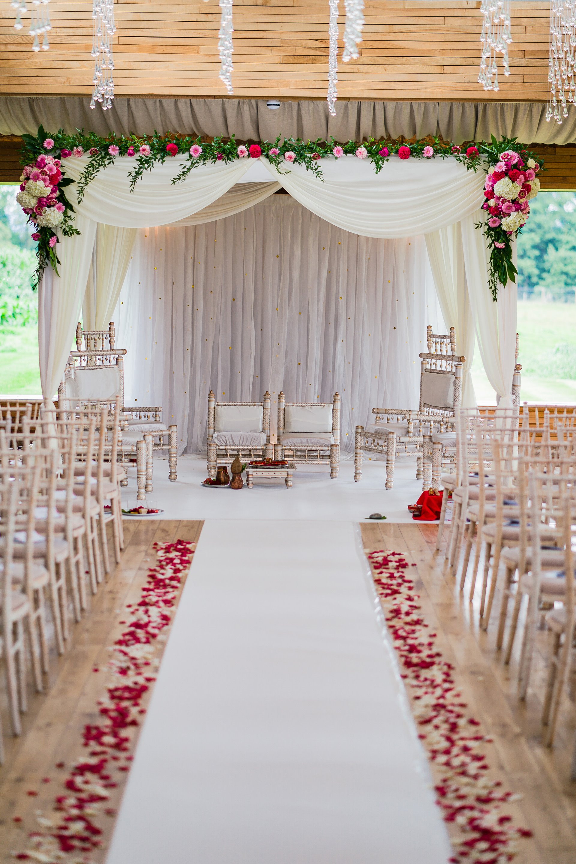 Beautiful white and pink Mandap with petal aisle in the Gillyflower at indian wedding venue elmore court