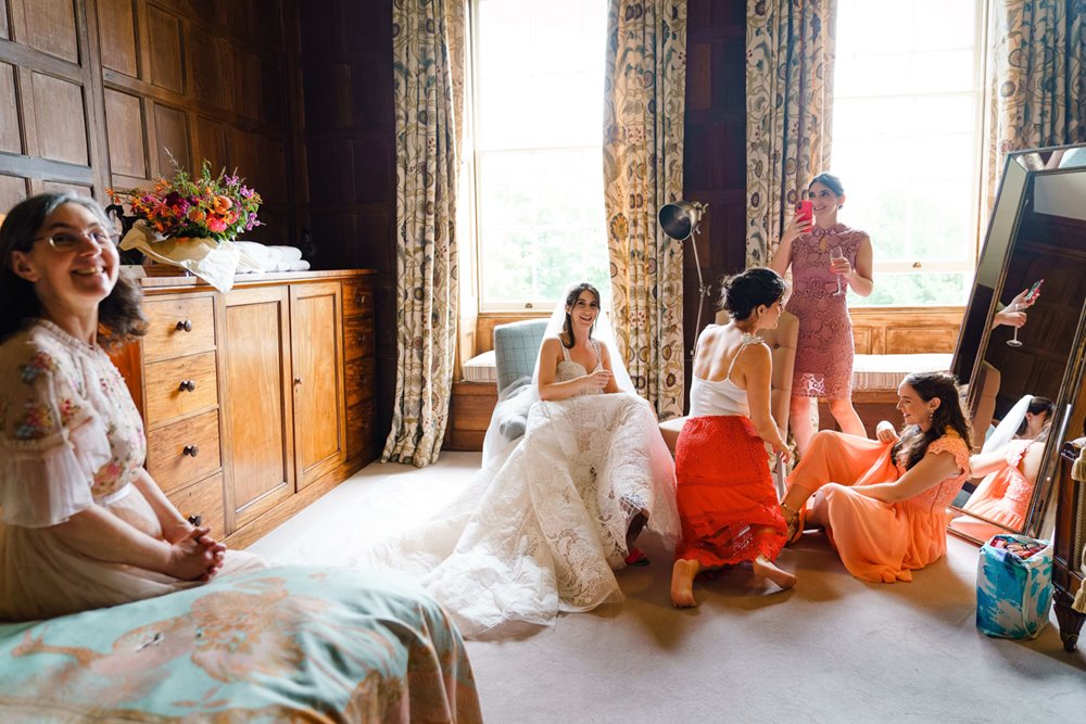Jewish bridal party waits for bedeken in luxurious bedroom of wedding venue